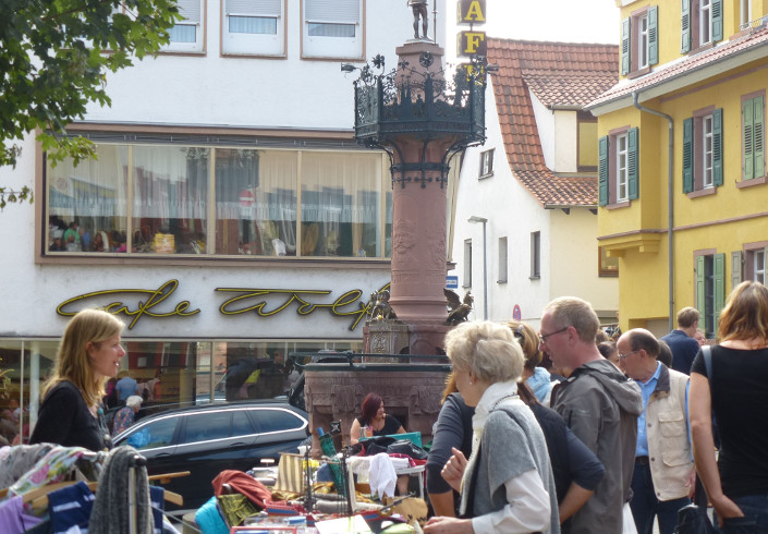 Rodensteiner Flohmarkt in Weinheim Flohmarkt in Weinheim, Flohmarktstand mit Menschen, die Gebrauchtes suchen und einer Frau, die Flohmarktstand betreibt