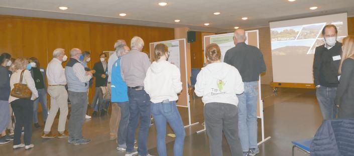 Zahlreiche Teilnehmend betrachten Schautafeln im Foyer.