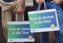 Zwei Taschen von Händen gehalten mit dem Schriftzug "Pack dir Heimat in die Tüte"