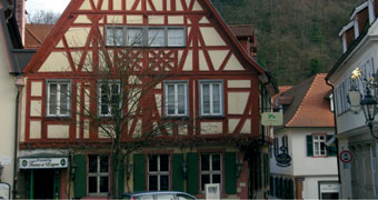 Fachwerkhaus in der Fußgängerzone mit Schild über dem Eingangsbereich